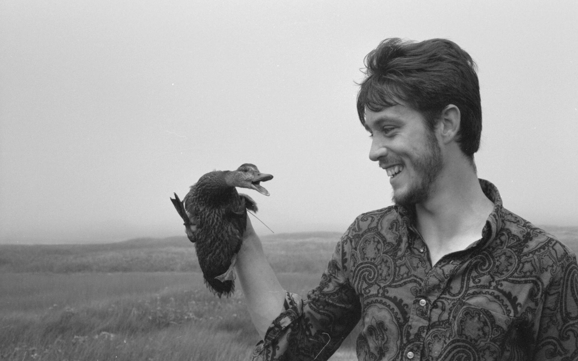 Pierre Norris of the meteorological station placing wild duckling back on nest